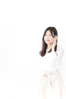 Genç Asyalı kadın telefonda konuşuyor.