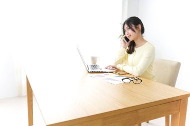 İş kadını ofiste telefonla konuşuyor.