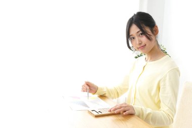 Ofisteki masada oturan iş materyali olan kadın. 