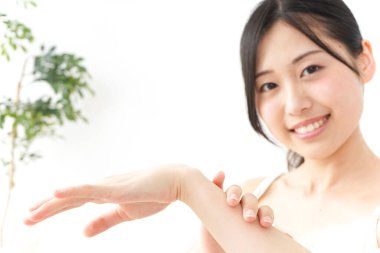 Genç Asyalı kadın krema üstüne el ele tutuşuyor.