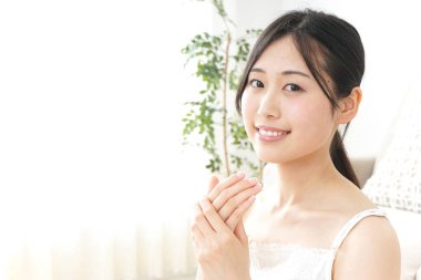 Genç Asyalı kadın krema üstüne el ele tutuşuyor.