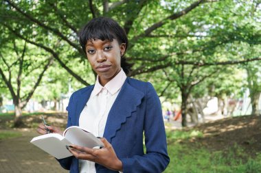 Kadın dışarıda notlar alıyor. 