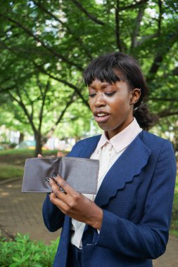 Dışarıda cüzdanı elinde tutan Afrikalı bir kadın.