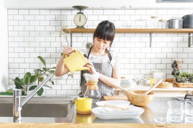 Genç Asyalı kadın damlatan kahve yapıyor.