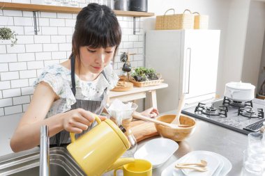 Genç Asyalı kadın damlatan kahve yapıyor.