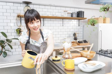 Genç Asyalı kadın damlatan kahve yapıyor.