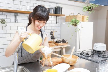 Genç Asyalı kadın damlatan kahve yapıyor.