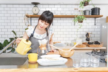 Genç Asyalı kadın damlatan kahve yapıyor.