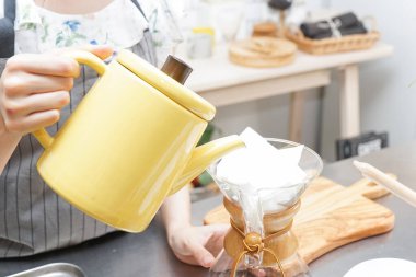 Genç Asyalı kadın damlatan kahve yapıyor.