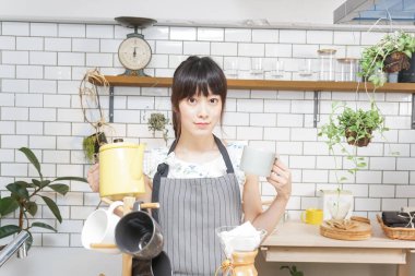 Genç Asyalı kadın damlatan kahve yapıyor.