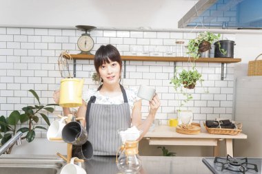 Genç Asyalı kadın damlatan kahve yapıyor.