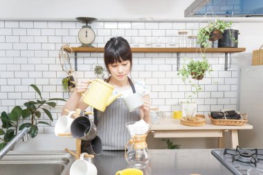 Genç Asyalı kadın damlatan kahve yapıyor.