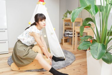 Asyalı genç bir kadın evde tek başına vakit geçiriyor.