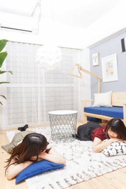 İki genç Asyalı kadın kapıda birlikte rahatlıyor.