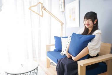 Takım elbiseli kadın kanepede otururken dinleniyor. 