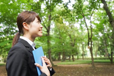 Mavi döküman klasörlü genç bir iş kadını.