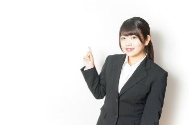 Takım elbiseli genç Asyalı kadın, parmak göstererek beyazı işaret ediyor.