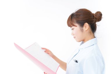 Genç Asyalı hemşire klasörü tutuyor.