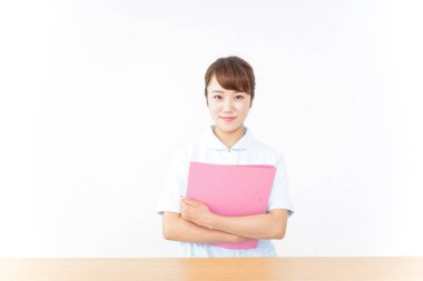 Genç Asyalı hemşire klasörü tutuyor.