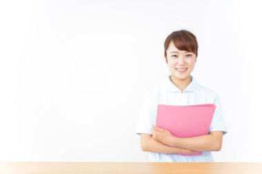 Genç Asyalı hemşire klasörü tutuyor.