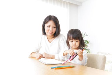 Anne ve çocuk evde birlikte çizim yapıyorlar.