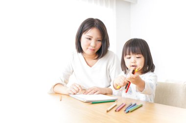 Anne ve çocuk evde birlikte çizim yapıyorlar.