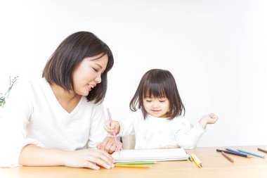 Anne ve çocuk evde birlikte çizim yapıyorlar.