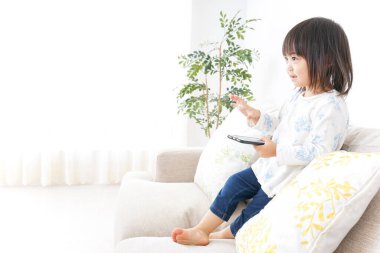 Odada akıllı telefon kullanan sevimli küçük çocuk. 