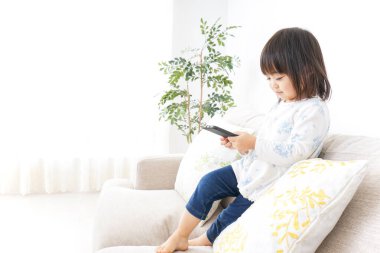 Odada akıllı telefon kullanan sevimli küçük çocuk. 