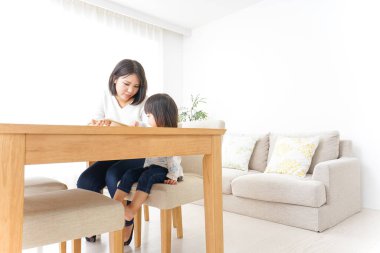 Anne ve çocuk evde birlikte oynuyorlar.