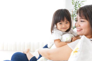 Anne ve çocuk evde birlikte oynuyorlar.