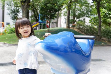 Parkta oynayan sevimli küçük çocuk.