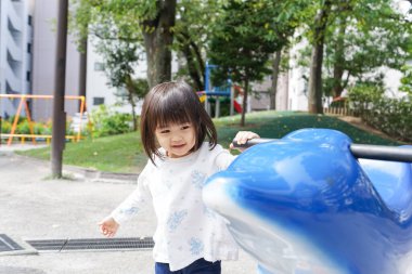 Parkta oynayan sevimli küçük çocuk.