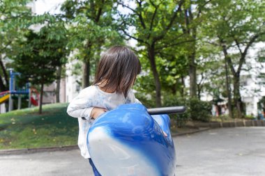 Parkta oynayan sevimli küçük çocuk.