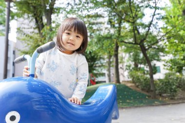 Parkta oynayan sevimli küçük çocuk.