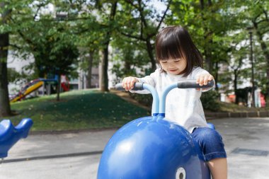 Parkta oynayan sevimli küçük çocuk.