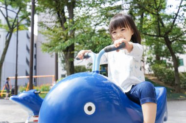 Parkta oynayan sevimli küçük çocuk.