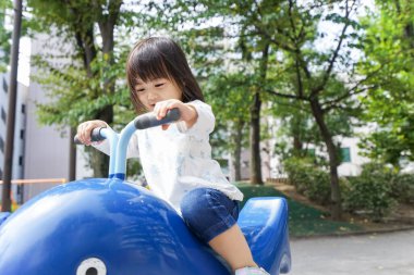 Parkta oynayan sevimli küçük çocuk.