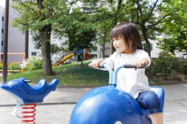 Parkta oynayan sevimli küçük çocuk.