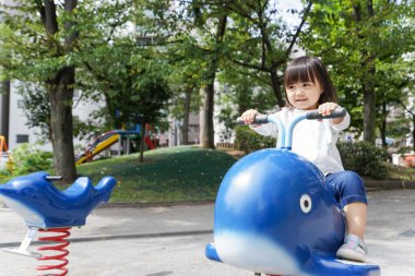 Parkta oynayan sevimli küçük çocuk.