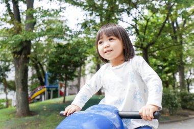 Parkta oynayan sevimli küçük çocuk.