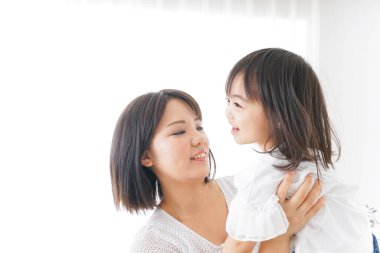 Anne ve çocuk evde birlikte poz veriyorlar.