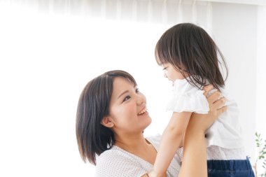 Anne ve çocuk evde birlikte poz veriyorlar.