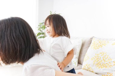 Anne ve çocuk evde birlikte poz veriyorlar.