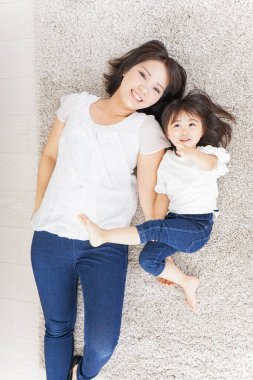 Anne ve çocuk halının üzerinde birlikte yatıyor.