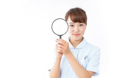 Büyüteçle genç Asyalı hemşire.