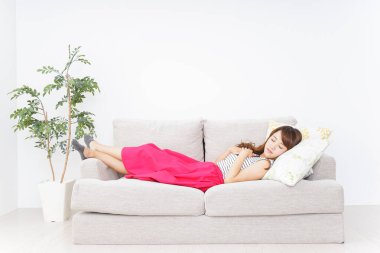 Kanepede uyuyan genç Asyalı kadın.