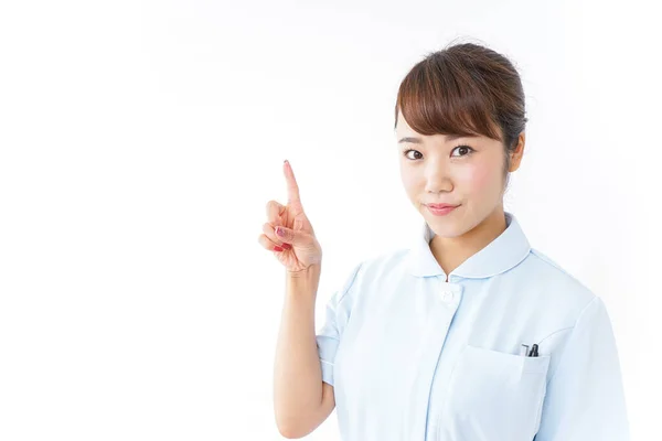 Junge Asiatische Krankenschwester Zeigt Mit Dem Finger Auf Weißem Hintergrund — Stockfoto