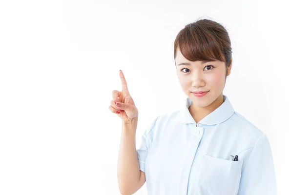 Junge Asiatische Krankenschwester Zeigt Mit Dem Finger Auf Weißem Hintergrund — Stockfoto