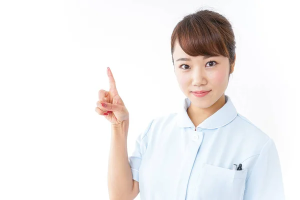 Junge Asiatische Krankenschwester Zeigt Mit Dem Finger Auf Weißem Hintergrund — Stockfoto